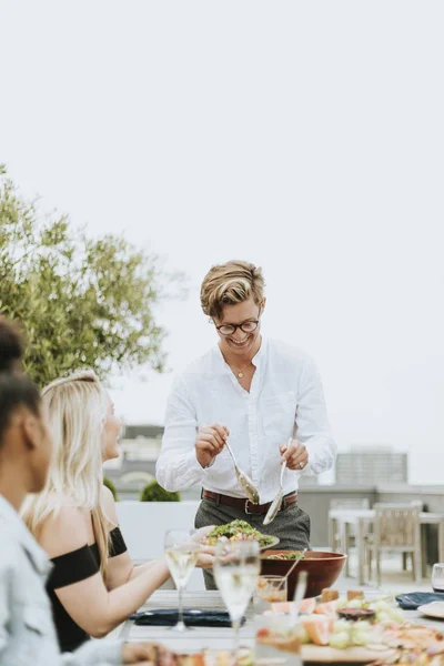 Homem Servindo Sua Salada Amigos Uma Festa Telhado — Fotografia de Stock