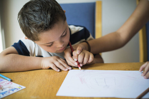 Girl helping her brother to draw