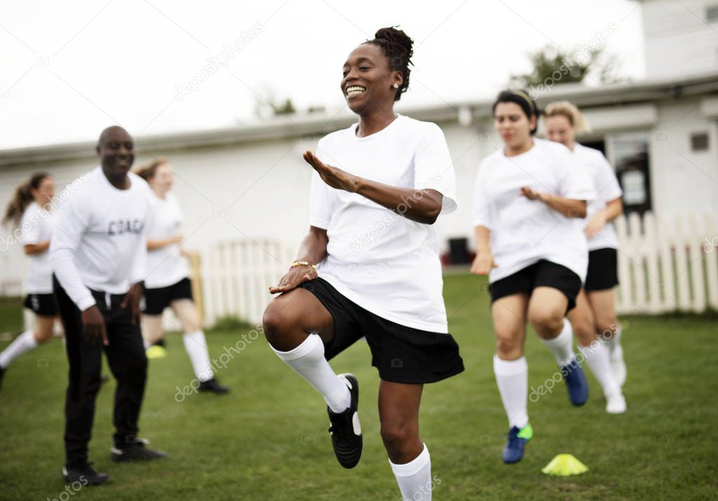 Female football players warming up on the field