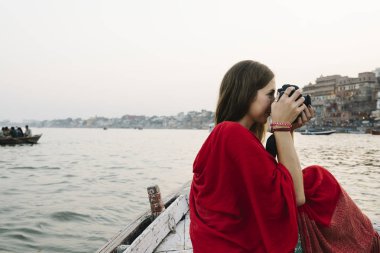 Ganj Nehri'nden fotoğraf çeken teknedeki gezgin