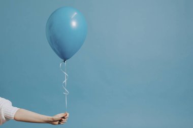 Pastel mavi balon tutan kız