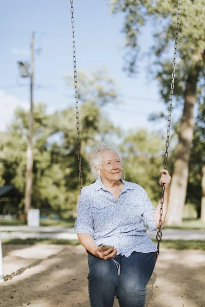 Glückliche Seniorin Hört Musik Auf Einer Schaukel — Stockfoto