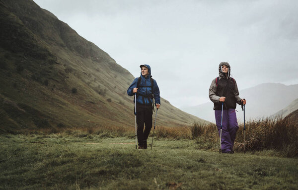 Couple trekking through the rain in the Highlands