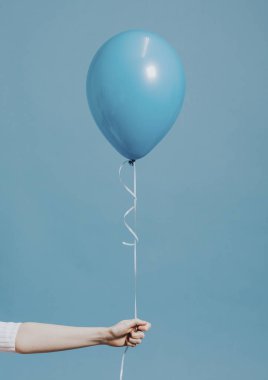 Pastel mavi balon tutan kız
