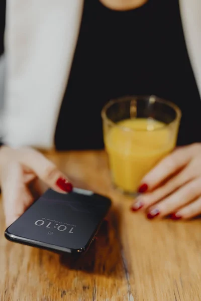 Frau Trinkt Ein Glas Saft Und Checkt Ihr Handy — Stockfoto