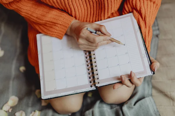 Woman writing on her daily planner