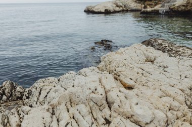 Sakin deniz yavaşça kayalara çarparak