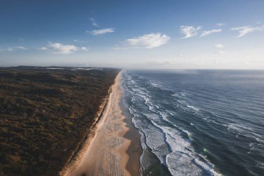 Drone görünümü bir kıyı şeridi mavi gökyüzü altında