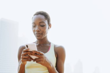 Moblie telefon ve bluetooth kulaklık kullanarak Spor kadın