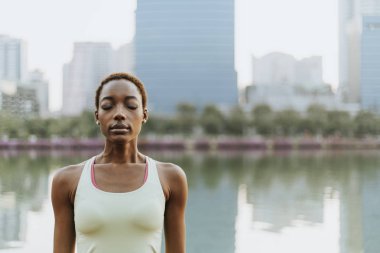Siyah bayan bir parkta meditasyon yapma
