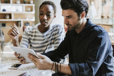 İş arkadaşları çalışmalarını tablette tartışıyor