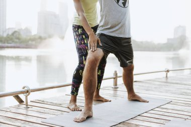 Bir parkta bir yoga yaparken çift