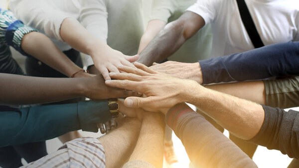 Разнообразная команда объединяет свои руки
