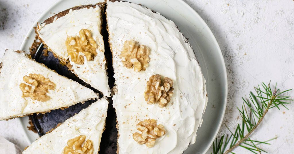 Sliced carrot cake topped with walnuts