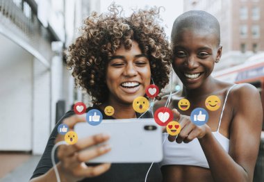 Siyah kadınlar bir telefondan canlı yayın izliyor