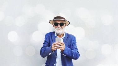 İhtiyar bir adamın cep telefonu kullanıyor