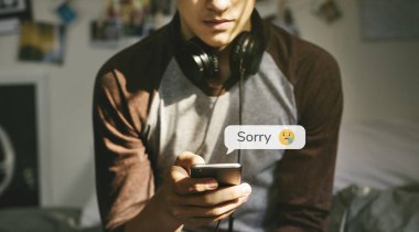 Onun telefon kullanarak boynunun etrafında kulaklıklar ile genç