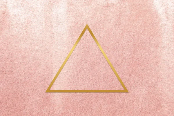 ローズゴールドの背景にゴールドの三角フレーム — ストック写真