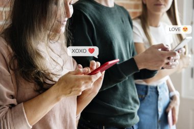 Akıllı telefonlarını kullanan mutlu arkadaşlar