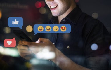 Neşeli genç adam telefonuna mesaj atıyor