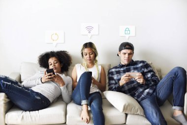 Telefonlarını kanepede kullanan insanlar