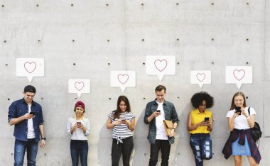 Telefonlarını kullanan farklı kişilerden oluşan bir grup