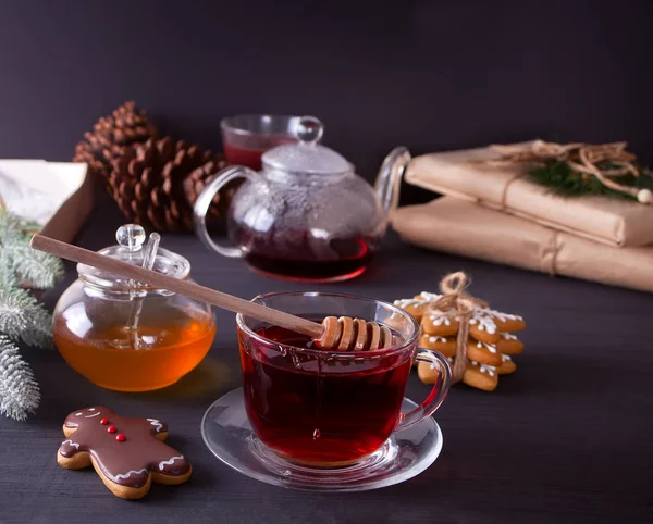 自家製クリスマス クッキー面白いジンジャーブレッド人と雪 はちみつと木製のテーブルの上の紅茶のカップ — ストック写真