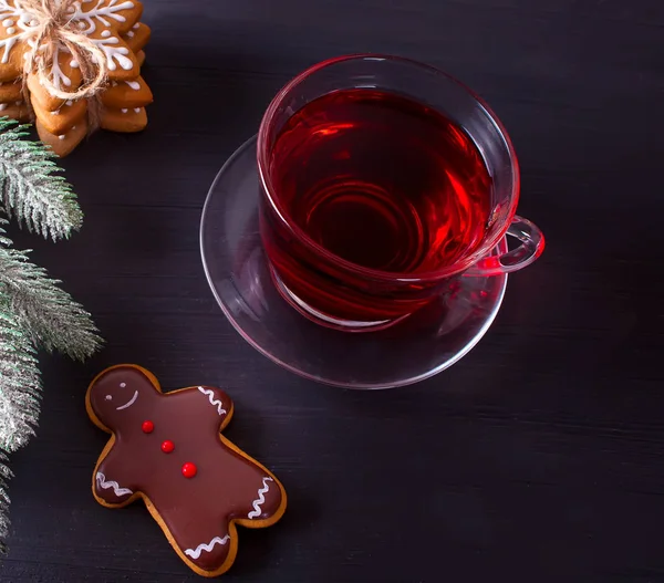 自家製クリスマス クッキー面白いジンジャーブレッドマンと木製のテーブルの上の紅茶のカップ — ストック写真