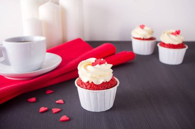 Fincan kahve ve ahşap masa kırmızı peçeteye kalpler ile cupcakes. Love Tema.