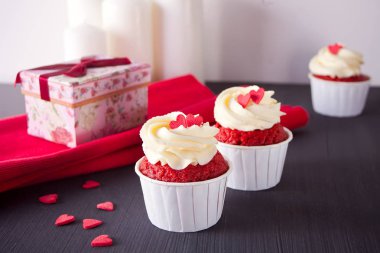 Fincan kahve ve ahşap masa kırmızı peçeteye kalpler ile cupcakes. Love Tema.