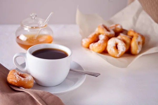 テーブルの上のコーヒー カップと新鮮な小さなドーナツ — ストック写真