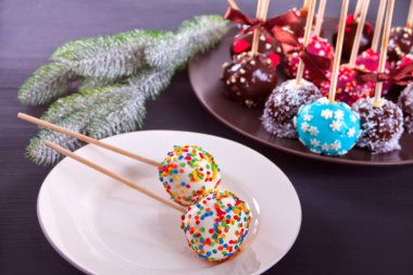 Ahşap bir masa üzerinde beyaz ve koyu çikolata ile dekore edilmiş çeşitli kek çıkar