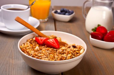 Müsli, çilek, suyu, bal ve süt beyaz bir arka plan ile bir tabak.