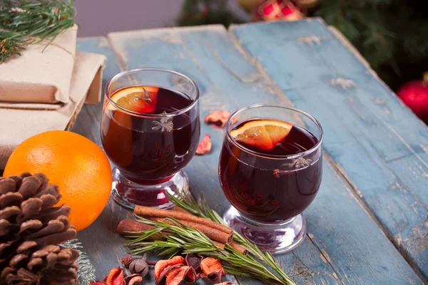クリスマスで 2 つのワイングラス マルド スパイスと木製の素朴なテーブルにフルーツと赤ワイン. — ストック写真