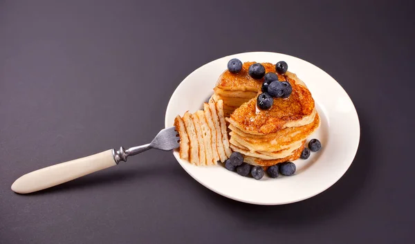 Pfannkuchen Mit Beeren Und Honig Auf Dem Schwarzen Tisch — Stockfoto