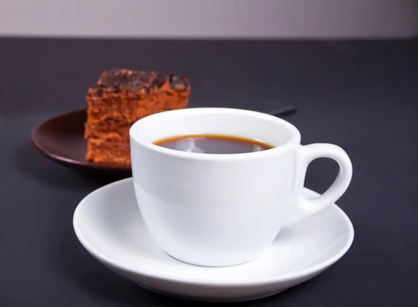 黒いテーブルの上のコーヒーのカップでおいしいチョコレート ケーキ — ストック写真