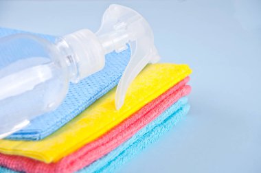 Mikrofiber havlu ve püskürtücü üzerinde mavi arka plan temizleme seti