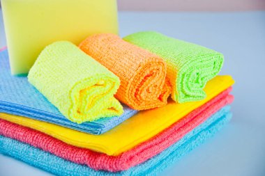 Mikrofiber havlu ve püskürtücü üzerinde mavi arka plan temizleme seti