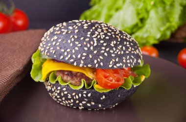 Ev yapımı siyah burger pirzola ve sebze plaka üzerinde.