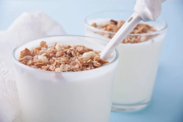 Granola com iogurte em vidro em uma mesa azul . — Fotografia de Stock