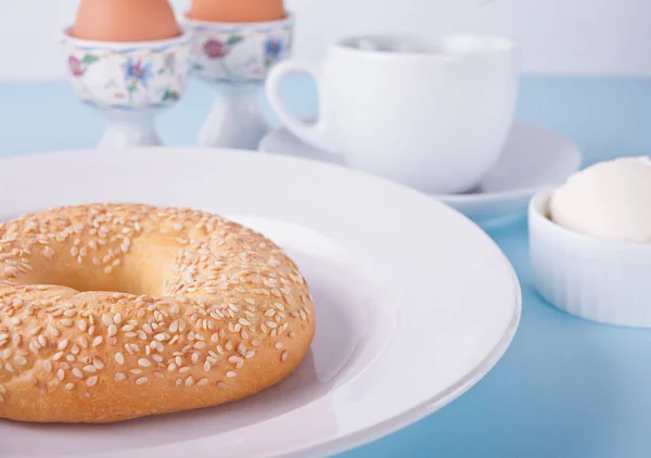 Bagel saudável fresco em um prato branco com xícara de café, queijo creme e ovos para o café da manhã — Fotografia de Stock