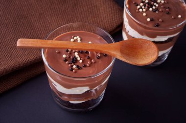 Bir tabloda tahta kaşık ile cam kavanozlara çikolata tatlı