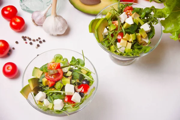 Färska blandade grönsaker sallad i en två skålar på vita bordet — Stockfoto