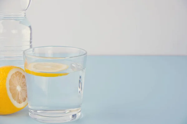 Agua con limón en la mesa azul — Foto de Stock