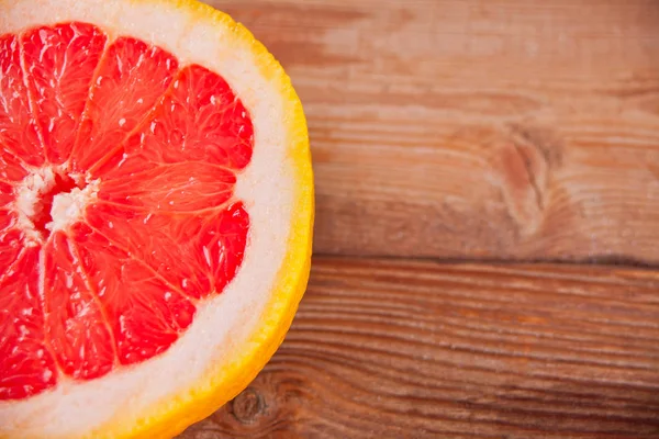 Slice of red grapefruit on old table