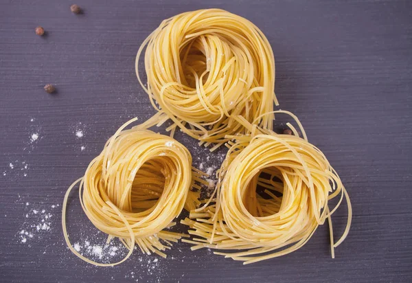Italian egg pasta nest on black background