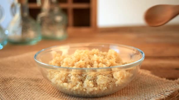 Frauenhand Gießt Gekochte Quinoa Körner Mit Schaufel Auf Hölzernen Küchentisch — Stockvideo