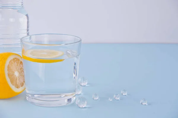 Agua con limón en la mesa azul — Foto de Stock