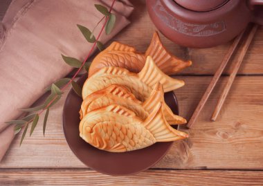 Ahşap masa üzerinde Taiyaki Japon sokak gıda balık şeklinde tatlı dolgu waffle