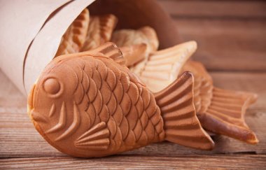 Ahşap masa üzerinde Taiyaki Japon sokak gıda balık şeklinde tatlı dolgu waffle